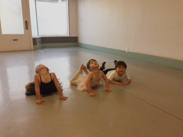 Three young dancers stretch during Serendipity