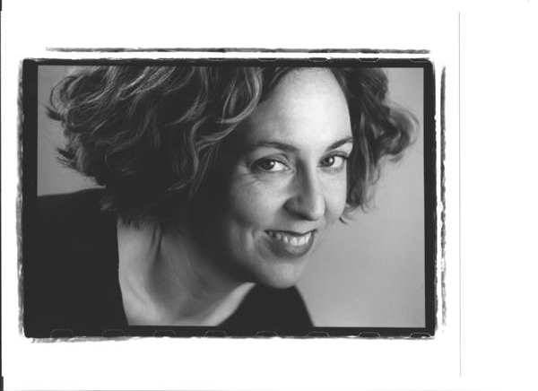 Mary's headshot. In black and white, Mary has short curly hair and smiles at the camera