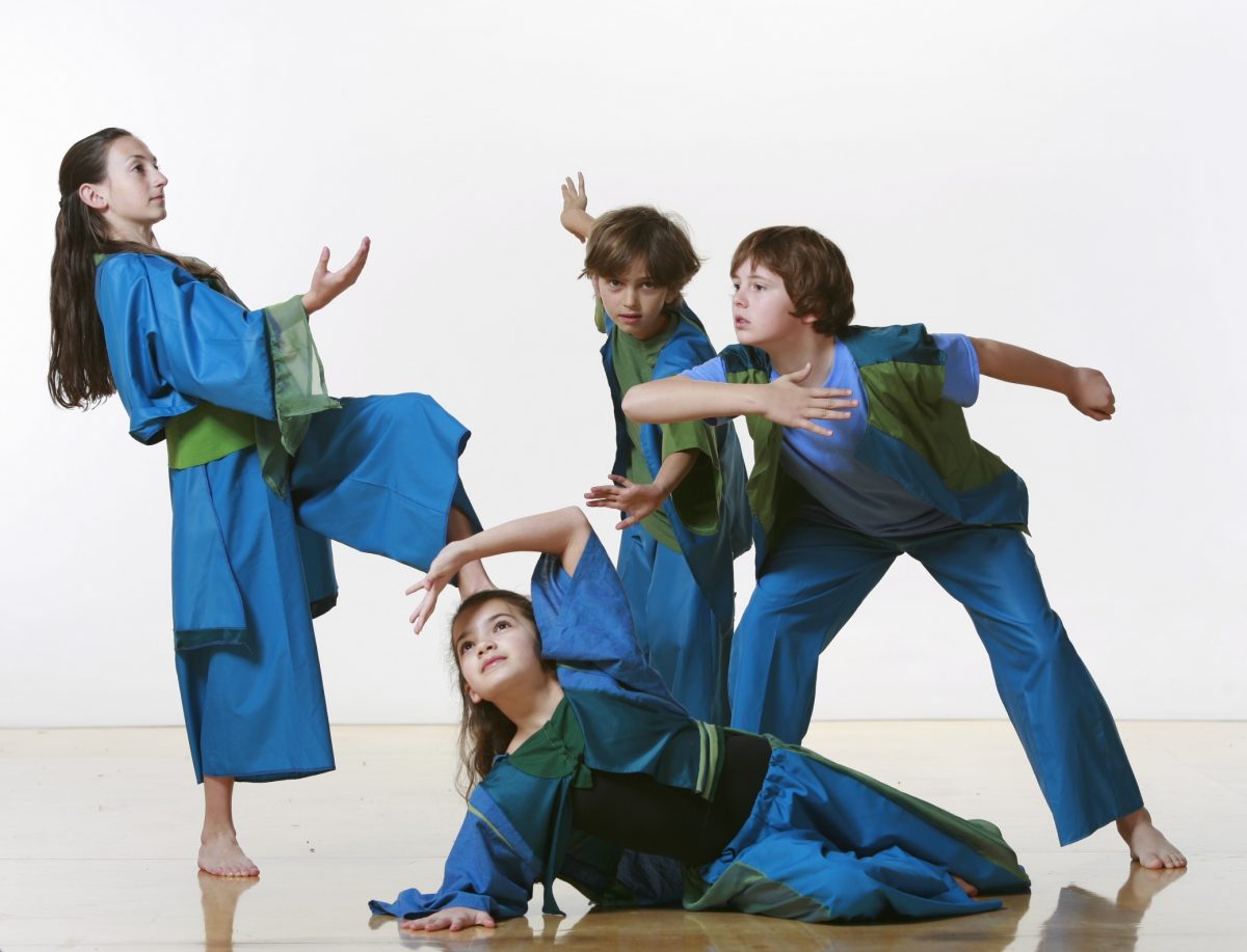 4 young dancers in blue and green costumes make various shapes