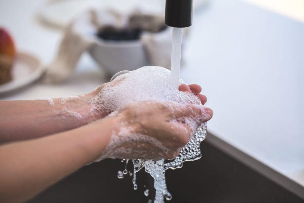 stock photos close up on hands washing at a sink.