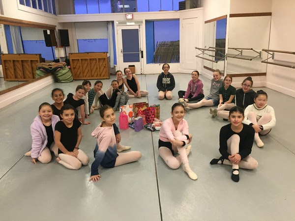 18 young dancers doing a gift exchange in the studio