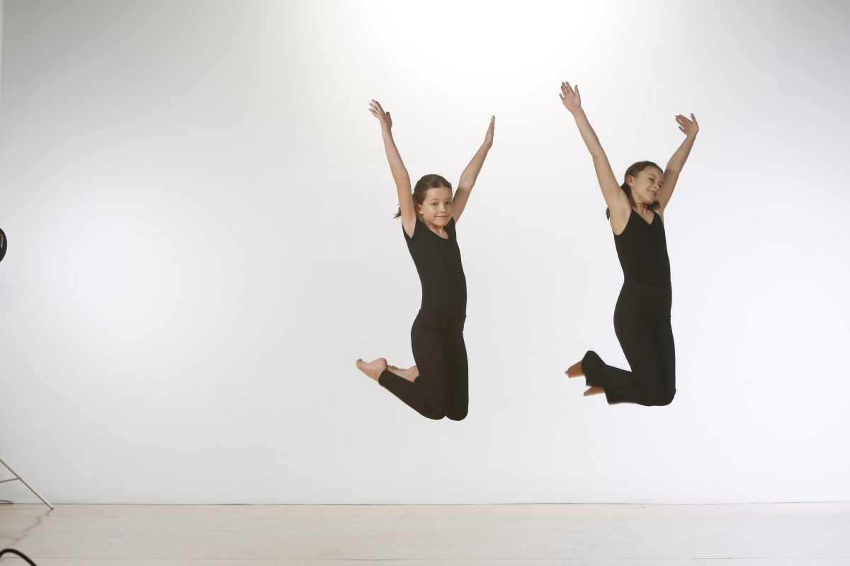Two young dancers jump joyfully