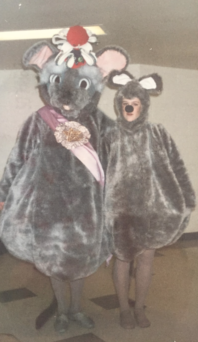 Scan of a photograph of KT Mower in a mouse costume next to the Mouse King during a Nutcracker performance.