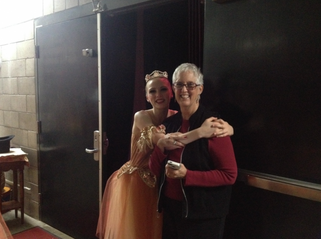 A dancer in costume backstage hugging Beth Hoge during a performance of the Nutcracker.