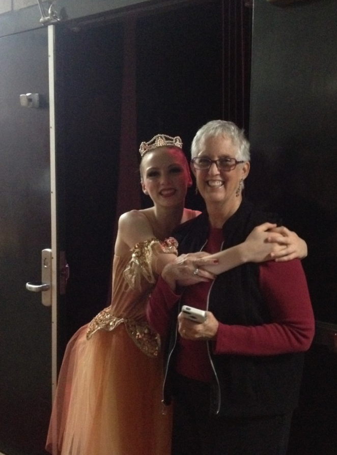 A dancer in costume backstage hugging Beth Hoge during a performance of the Nutcracker.