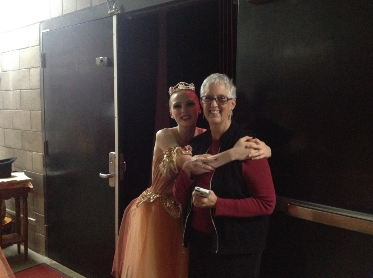 A dancer in costume backstage hugging Beth Hoge during a performance of the Nutcracker.