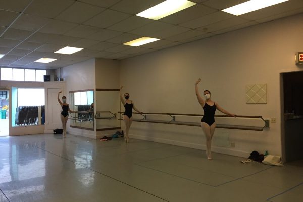 3 teen dancers in class in masks pose in sous-sous.