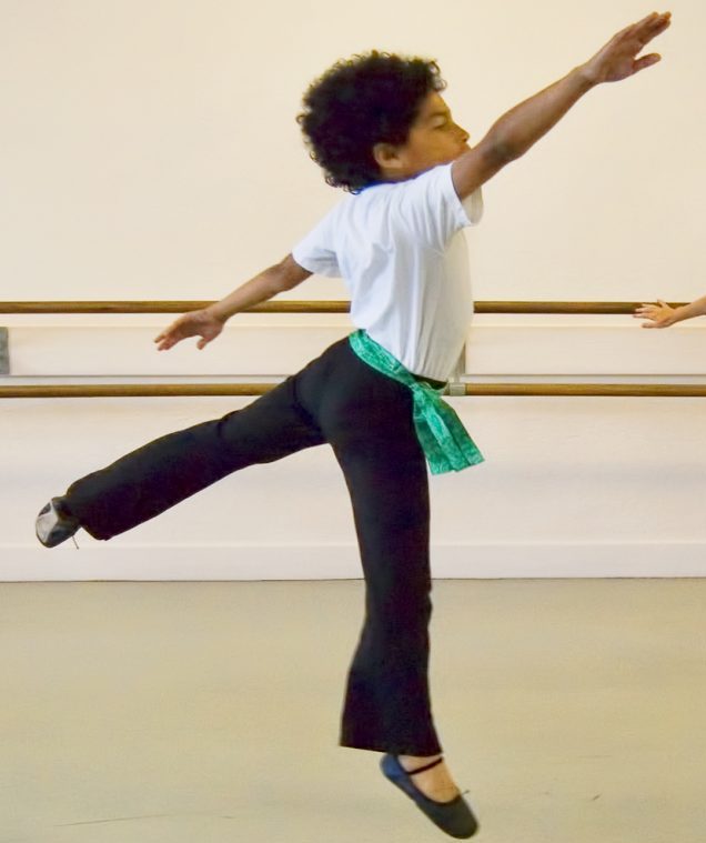 Two young male dancers in a costume mid-dance.